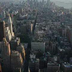 An aerial view shows a densely populated urban area with many tall buildings and skyscrapers.