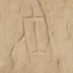 A beige rock face featuring a rectangular, humanoid petroglyph.