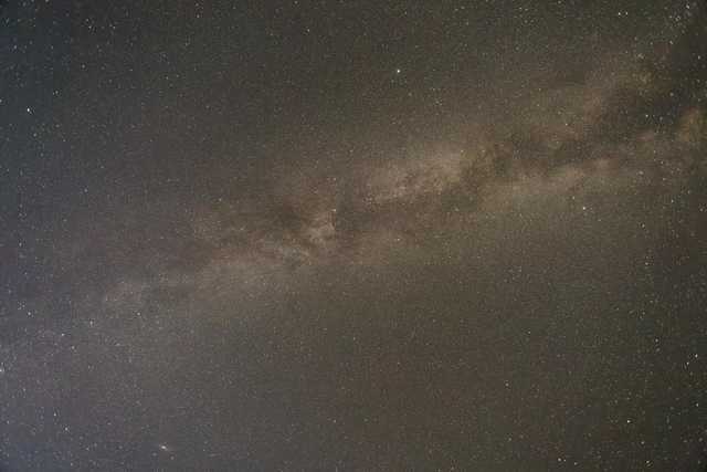 The Milky Way galaxy displays dense bands of stars and dust in the night sky.