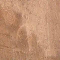 A brown stone surface features faint circular markings on its left side.