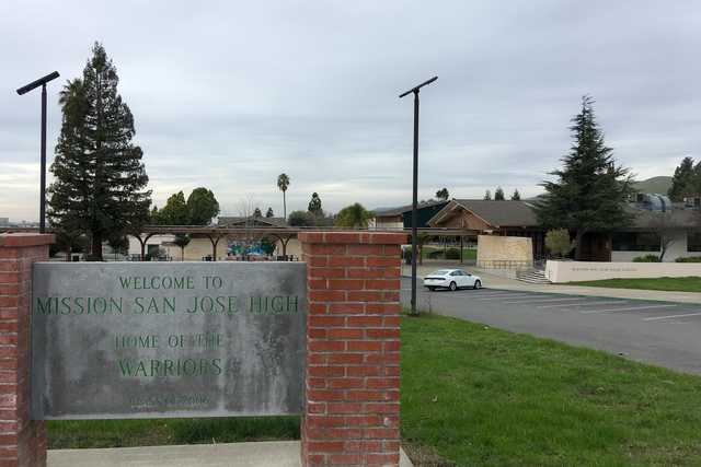 A large building with a covered entrance is visible behind a red brick sign that reads "Welcome to Mission San Jose High".