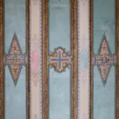 A ceiling features a light blue background with ornate gold and brown trim, adorned with decorative shapes along the edges.