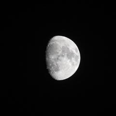 An almost full moon is visible against a black background.