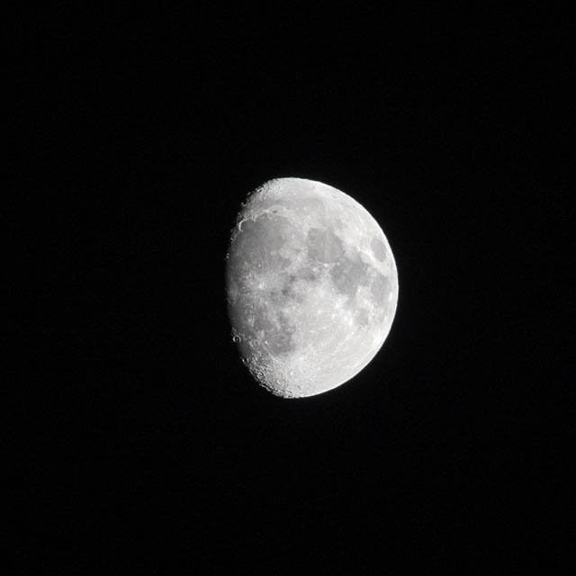 An almost full moon is visible against a black background.