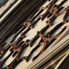 A close-up of a weathered facade shows peeling paint and ornate architectural details.