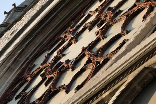 A close-up of a weathered facade shows peeling paint and ornate architectural details.