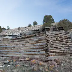An old wooden cabin is constructed from logs stacked horizontally on top of each other.