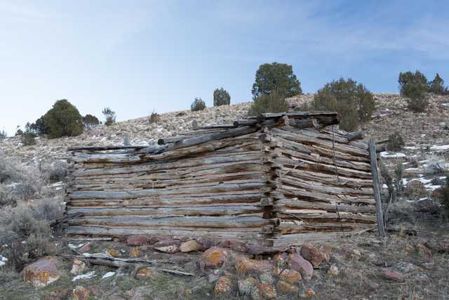 An old wooden cabin is constructed from logs stacked horizontally on top of each other.
