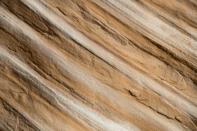 A close-up of sandstone features diagonal grooves.
