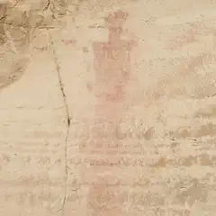 An ancient red pictograph on a light-colored rock surface, depicting a human figure.