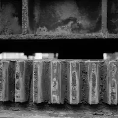 A row of metal teeth extends horizontally beneath a dark, angled structure.