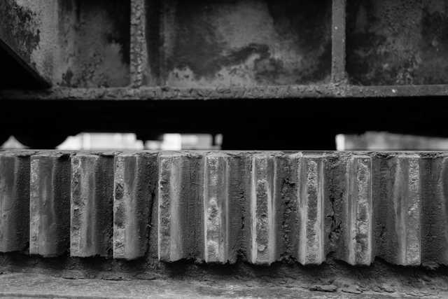 A row of metal teeth extends horizontally beneath a dark, angled structure.