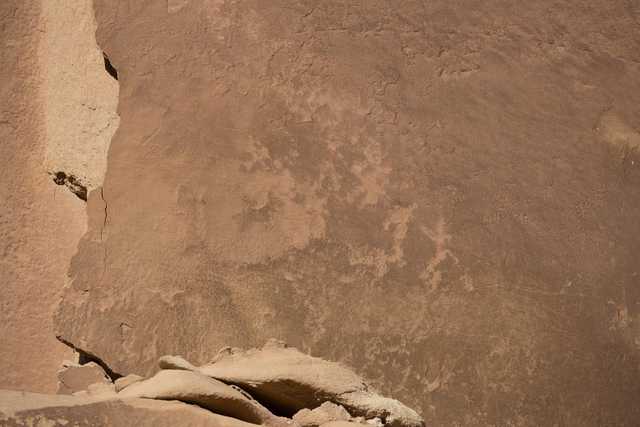 A tall rock formation with smooth, curved surfaces and rough edges.