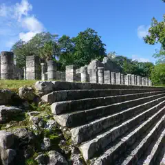A wide stone staircase leads up to a row of columns.