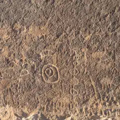 A weathered stone surface with a circular pattern etched into the center.