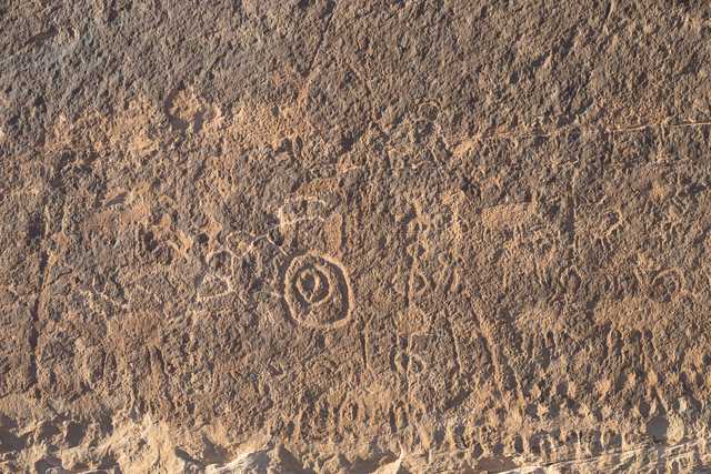 A weathered stone surface with a circular pattern etched into the center.