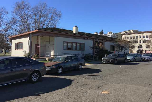 A white building with brown trim and a dark roof has a sign reading 'LAKEVIEW BRANCH LIBRARY' above its entrance.
