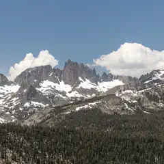 A mountain range with snow-covered peaks and rocky summits is visible in the background.