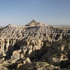 A rugged, rocky landscape with steep, eroded hills and sparse vegetation.