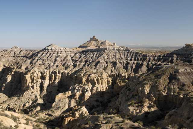 A rugged, rocky landscape with steep, eroded hills and sparse vegetation.