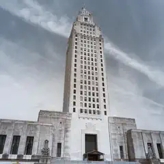 A tall, white, art deco style building with a central tower and rectangular wings.