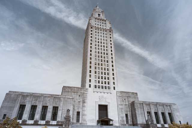 A tall, white, art deco style building with a central tower and rectangular wings.