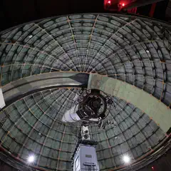 An astronomical telescope is visible inside a dome.