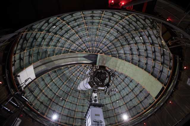 An astronomical telescope is visible inside a dome.