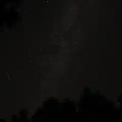 A night sky filled with stars and a single shooting star.