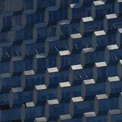 A facade of a building covered in blue-tinted glass panels arranged in a geometric pattern.
