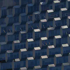 A facade of a building covered in blue-tinted glass panels arranged in a geometric pattern.
