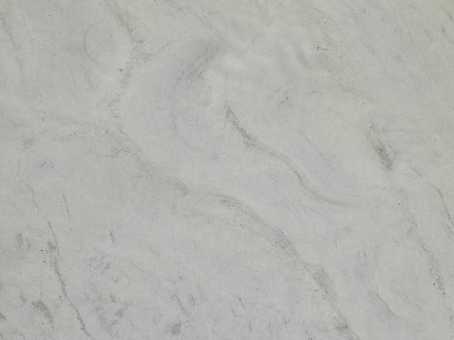 A close-up view of a marbled surface with light and dark veins running through it, giving an impression of natural stone.