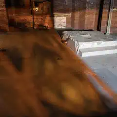 A stone floor in an old building with shadows from sunlight filtering through the windows.
