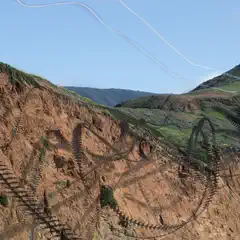 A rugged mountain landscape with traces of birds soaring across the frame.