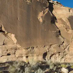 A large light-brown rock formation dominates the background.