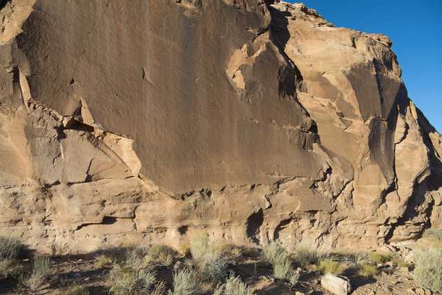 A large light-brown rock formation dominates the background.