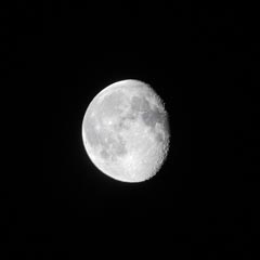 A bright, white moon is shown against a black background, with visible craters on its surface.