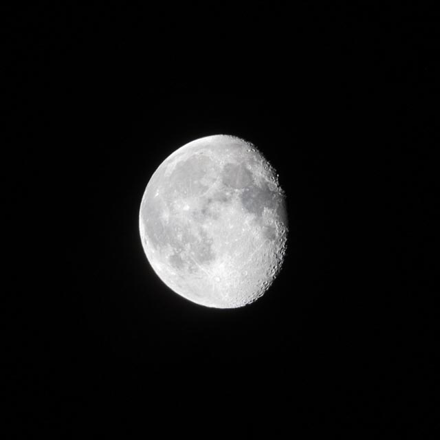 A bright, white moon is shown against a black background, with visible craters on its surface.