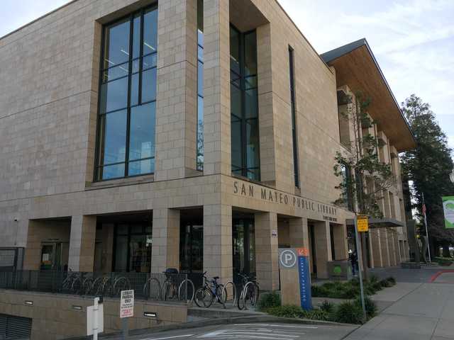 A modern library building with large windows and a sign that reads "San Mateo Public Library".