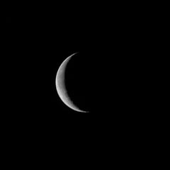 A crescent moon against a dark night sky.