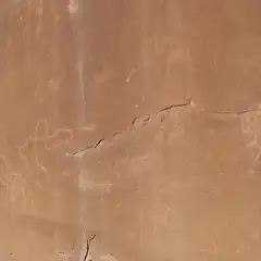 A light-colored rock face features several abstract shapes etched into its surface.