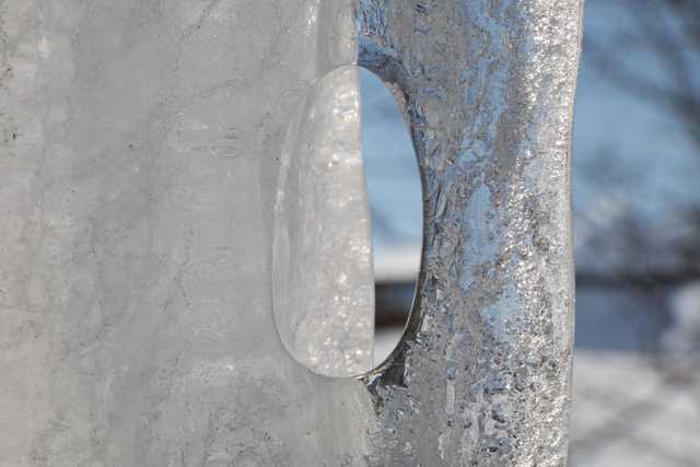 An oval-shaped hole is visible in a block of ice.