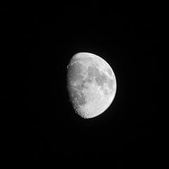 The moon, shining brightly against the dark night sky.