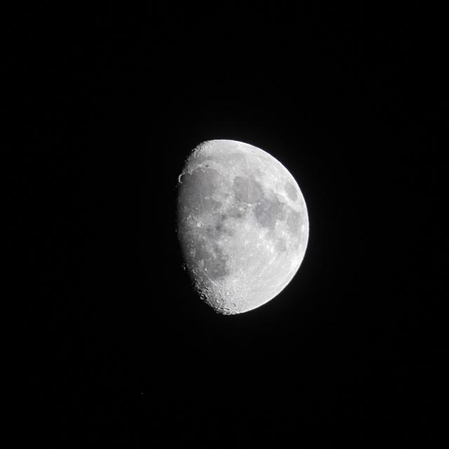 The moon, shining brightly against the dark night sky.