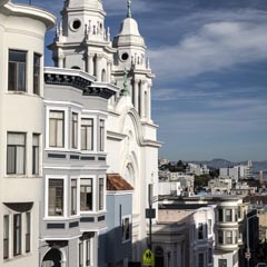 A white church with two towers overlooking a city.