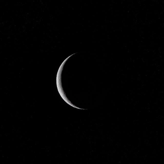 A crescent moon against a dark night sky.