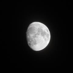 An almost full moon is shown against a black background.