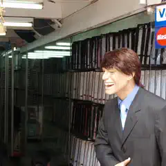 A mannequin in a suit stands in front of a wall of dress shirts, with a Visa and Mastercard sign visible on the right.