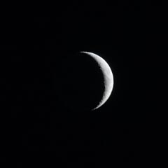 A crescent moon against a dark night sky.
