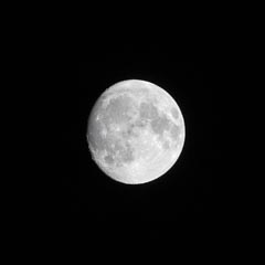 A full moon shining brightly against a dark night sky.
